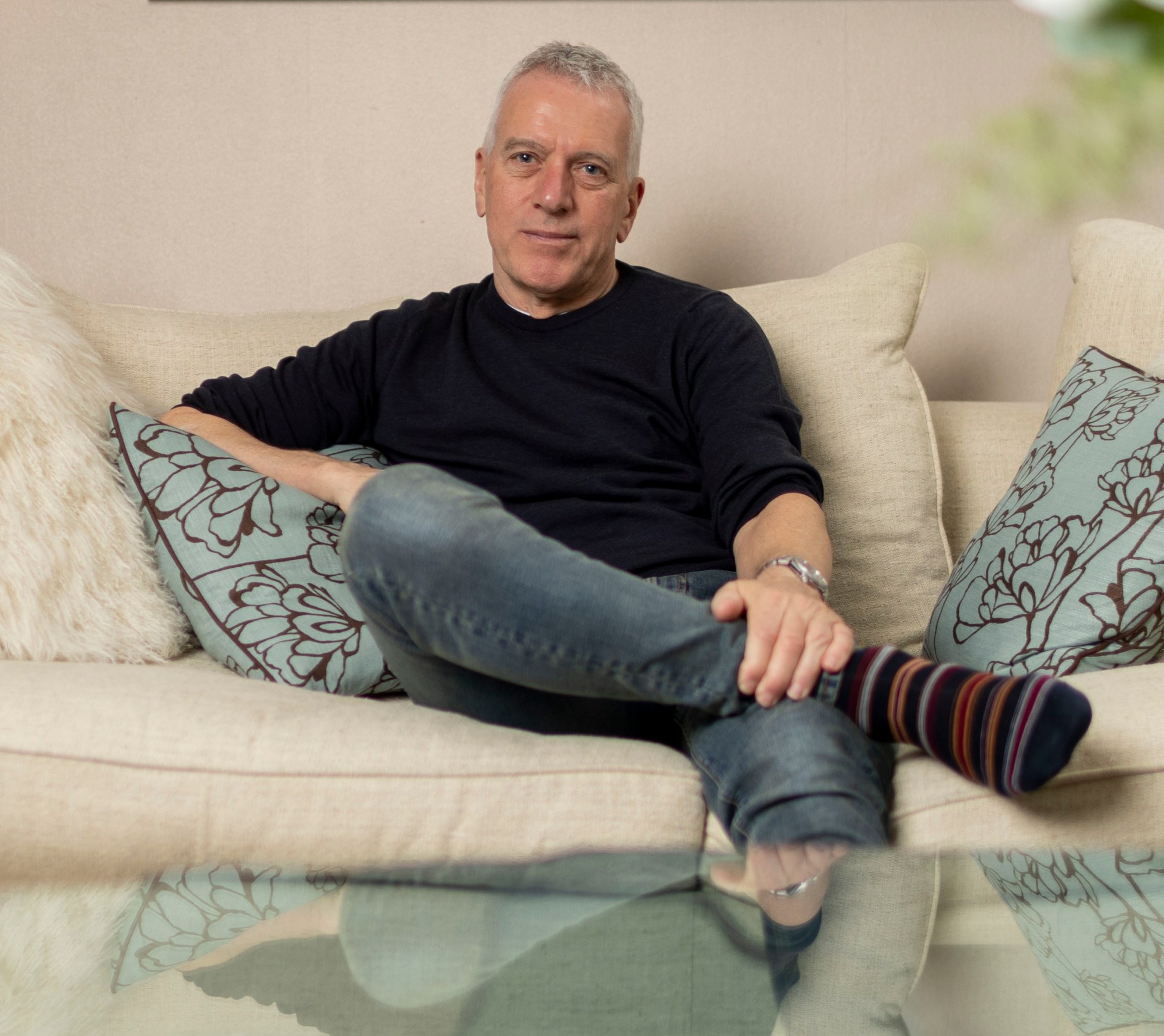 Portrait of Stan Boland sitting on a couch.