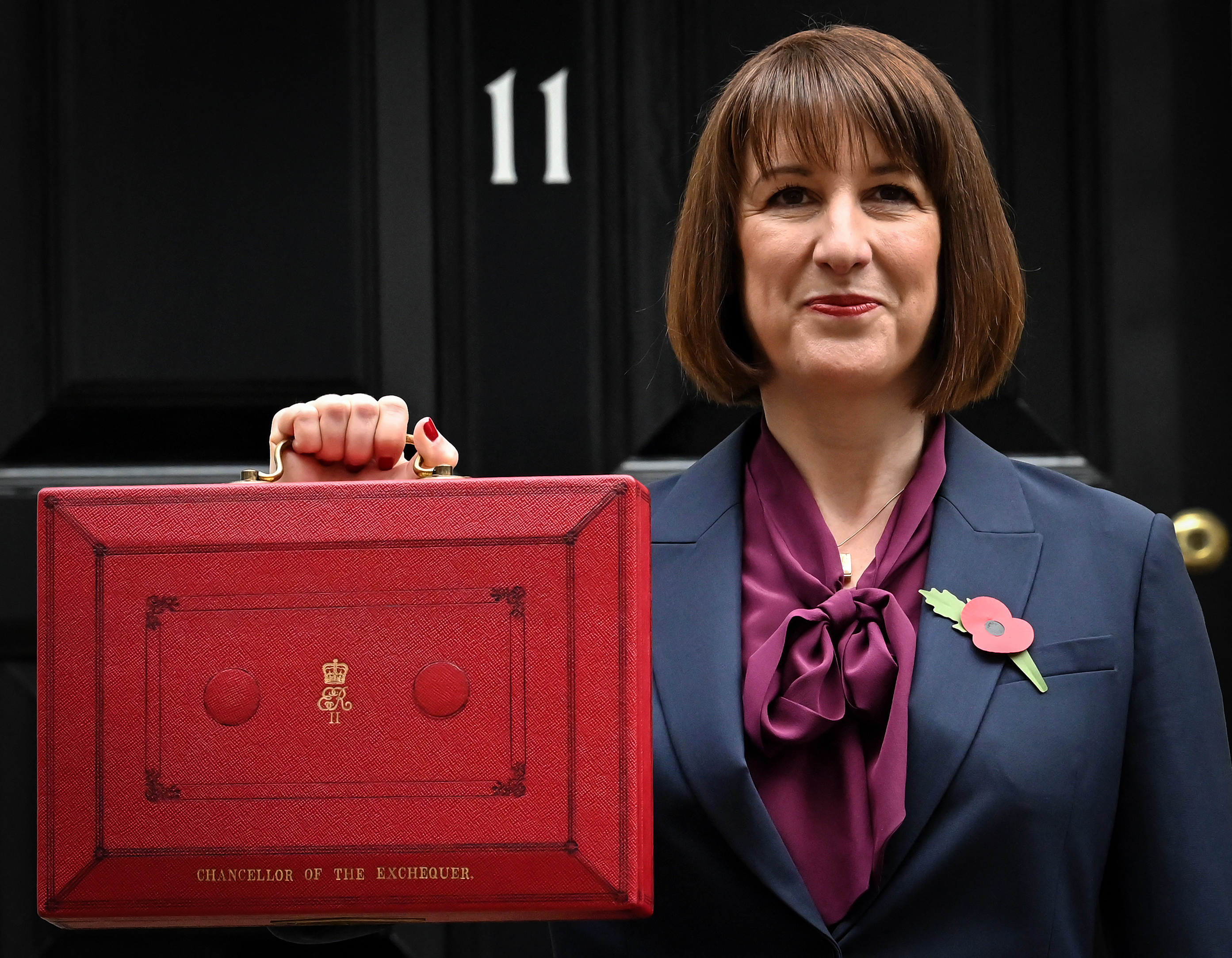 a woman holding a red briefcase that says ' chancellor of the exchequer ' on it